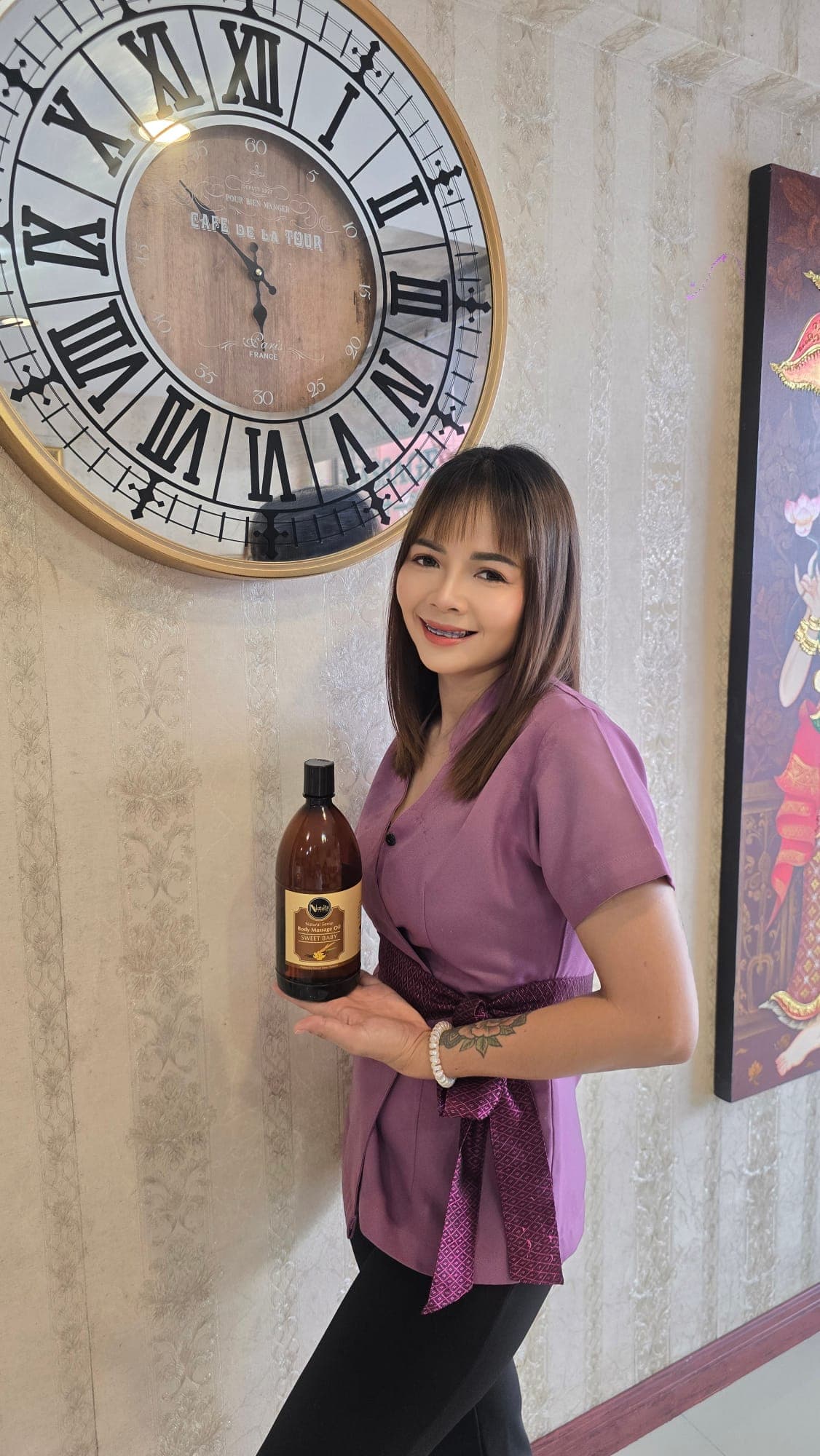 Therapist holding premium massage oil at Cher Ploy